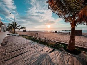 una passerella sulla spiaggia con palme e il tramonto di Acogedor, amplio a 5 min de Las Palmas-Esmeraldas a Esmeraldas