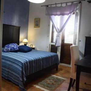 Un dormitorio con una cama con almohadas azules y una ventana en Casa Vacanza LA PALMA Selinunte Sicilia, en Marinella di Selinunte