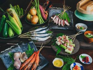 una tabella ricoperta con diversi tipi di alimenti su piatti di 古民家宿るうふ 丘之家 Okanoie a Yamanashi