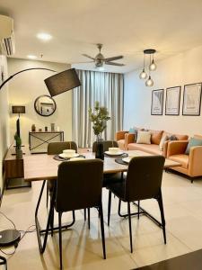 ein Esszimmer und ein Wohnzimmer mit einem Tisch und Stühlen in der Unterkunft New Arcoris Mont Kiara Huge Balcony for 8 pax 2 BR -Garden- in Kuala Lumpur
