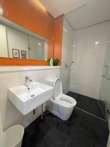 ein Badezimmer mit einem Waschbecken, einem WC und einem Spiegel in der Unterkunft New Arcoris Mont Kiara Huge Balcony for 8 pax 2 BR -Garden- in Kuala Lumpur
