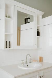 La salle de bains blanche est pourvue d'un lavabo et d'un miroir. dans l'établissement Cottage on Gray - Wangaratta, à Wangaratta