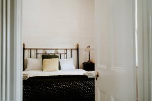 a bedroom with a bed with white sheets and pillows at Cottage on Gray - Wangaratta in Wangaratta