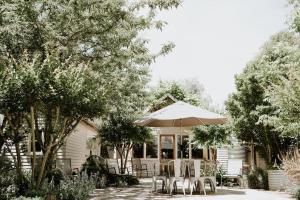 a patio with chairs and an umbrella in front of a house at Cottage on Gray - Wangaratta in Wangaratta