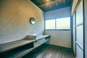 山梨的住宿－古民家宿るうふ 丘之家 Okanoie，一间带水槽和窗户的浴室