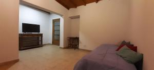 a bedroom with a bed and a flat screen tv at Casa Mármol 2085 MDZ Mendoza in Godoy Cruz