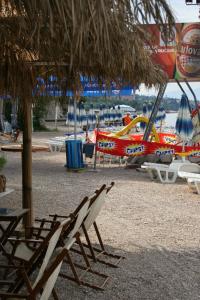 a group of chairs and a boat on a beach at Apartments by the sea Dramalj, Crikvenica - 2387 in Dramalj