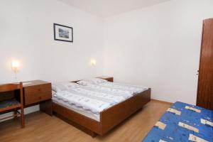 a small bedroom with a bed and a desk at Apartments by the sea Supetarska Draga - Gornja, Rab - 2016 in Supetarska Draga