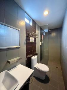 a bathroom with a white toilet and a sink at Metroinn Hotel in Arau