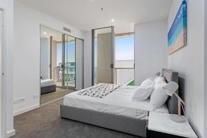 a bedroom with a bed and a large window at KULA Sydney Airport in Sydney