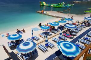 a beach with chairs and umbrellas and people on it at Apartment Selce 2372c in Selce