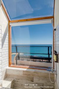 a bathroom window with a view of the ocean at Chuanfanrock Haku Beach Days Inn in Eluan