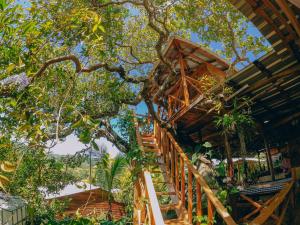 a tree house with a staircase leading up to it at EL GALLO ECOLODGE in San Felipe de Puerto Plata