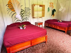 1 dormitorio con 2 camas con sábanas rojas en Cabañas Ixaya en Catemaco