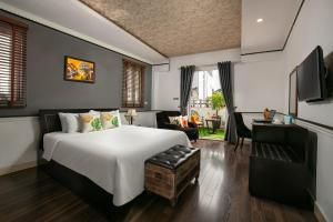 een slaapkamer met een groot wit bed en een bureau bij Hanoi Garden Hotel & Spa in Hanoi