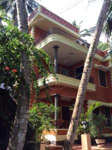 a house with palm trees in front of it at Reuben Villa in Kovalam