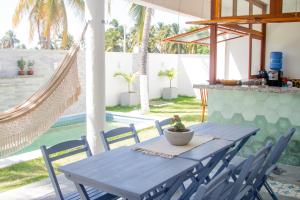 une table bleue et des chaises sur une terrasse avec un hamac dans l'établissement Casa Morica! Casa nova com Piscina!, à Icaraí