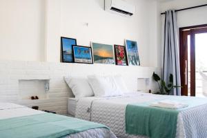 - une chambre avec 2 lits et des photos sur le mur dans l'établissement Casa Morica! Casa nova com Piscina!, à Icaraí