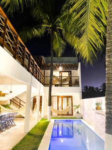 une maison avec une piscine et un palmier dans l'établissement Casa Morica! Casa nova com Piscina!, à Icaraí