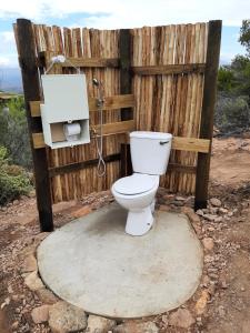 a toilet in front of a wooden fence at Joel's Off Grid Cottage in the Klein Karoo in Oudtshoorn +43 photos