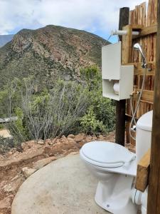 a toilet sitting outside in front of a mountain at Joel's Off Grid Cottage in the Klein Karoo in Oudtshoorn