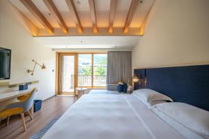 a large bedroom with two beds and a desk at voco Nanjing Garden Expo, an IHG Hotel in Nanjing