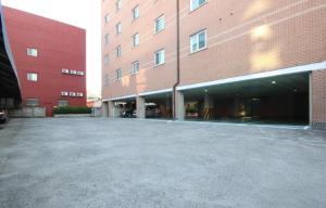 an empty parking lot in front of a brick building at Utopia Hotel in Gumi