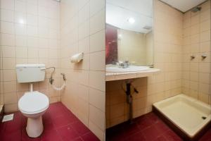 a bathroom with a toilet and a sink and a tub at OYO 90124 Payang Puri Baru Hotel in Sarikei