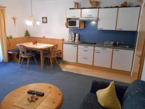 a living room with a table and a kitchen at Pfannelerhof in Leutasch