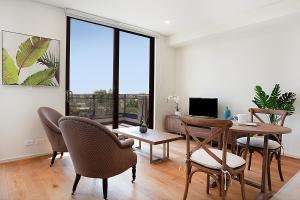 - un salon avec une table à manger et des chaises dans l'établissement KULA North Sydney, à Sydney