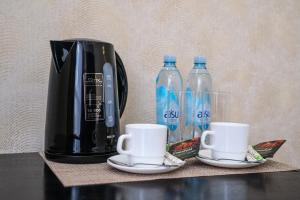 a coffee maker and two bottles of water on a table at Belon Lux Hotel in Astana