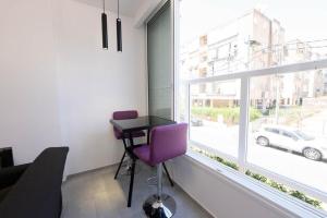 a room with a purple chair and a table and a window at New! luxus- Best suit 2 minutes fromTel Aviv in Bat Yam