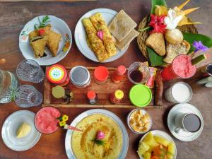 una mesa de madera con platos de comida. en Sumatra Orangutan Discovery Villa, en Bukit Lawang