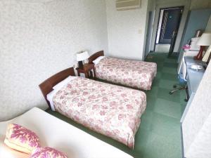a hotel room with two beds in a room at Pension Moon Villa in Onna