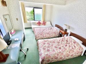 a hotel room with two beds and a window at Pension Moon Villa in Onna