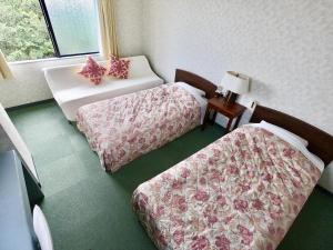 a hotel room with two beds and a window at Pension Moon Villa in Onna