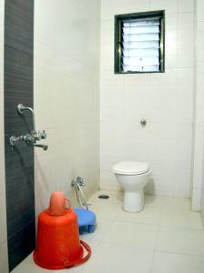 a bathroom with a toilet and a window at Hotel Sai Kamal in Shirdi