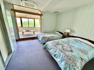 a bedroom with two twin beds and a window at Pension Moon Villa in Onna
