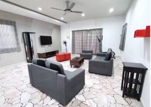 a living room with two couches and a flat screen tv at SingLeisure Holiday House in Mersing
