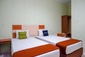 two beds in a hotel room withacersacers at Urbanview Hotel Platinum Parepare in Parepare