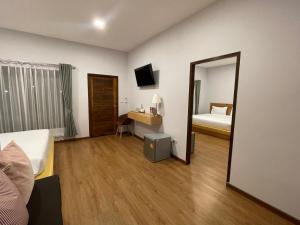 ein Hotelzimmer mit Bett und Spiegel in der Unterkunft Intha Resort in Ban Khao Lao