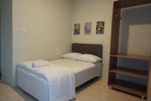 a small bedroom with a bed with white sheets at Alexandria12 Guest House in Selong