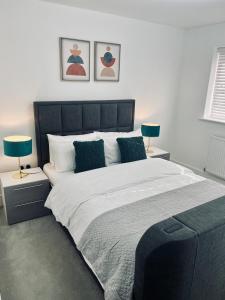a bedroom with a large bed with two lamps at My Chester Luxury Home in Colchester