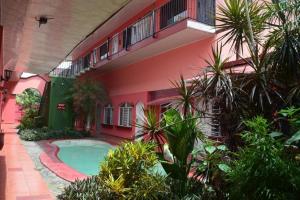 a building with a swimming pool in a courtyard at ECONOMiKA in Jacó