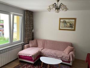 een woonkamer met een roze bank en een tafel bij Villa Rosa in Krayni Dol