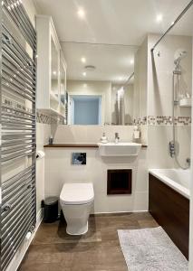 a bathroom with a toilet and a sink and a tub at My Chester Luxury Home in Colchester