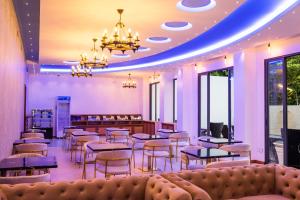 una sala de espera con sofá, mesas y sillas en Ari Grand Hotel & Spa en Dhangethi