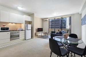 a kitchen and dining room with a table and chairs at KULA North Sydney-Napier in Sydney