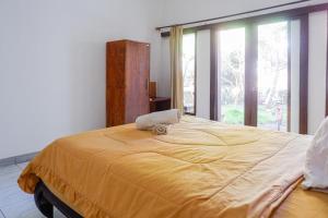 ein großes gelbes Bett in einem Zimmer mit Fenster in der Unterkunft Bukit Garden Gili Trawangan in Gili Trawangan