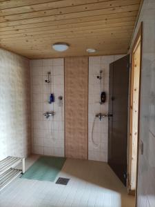 a bathroom with two shower stalls and two sinks at Hotelli Patruuna in Imatra